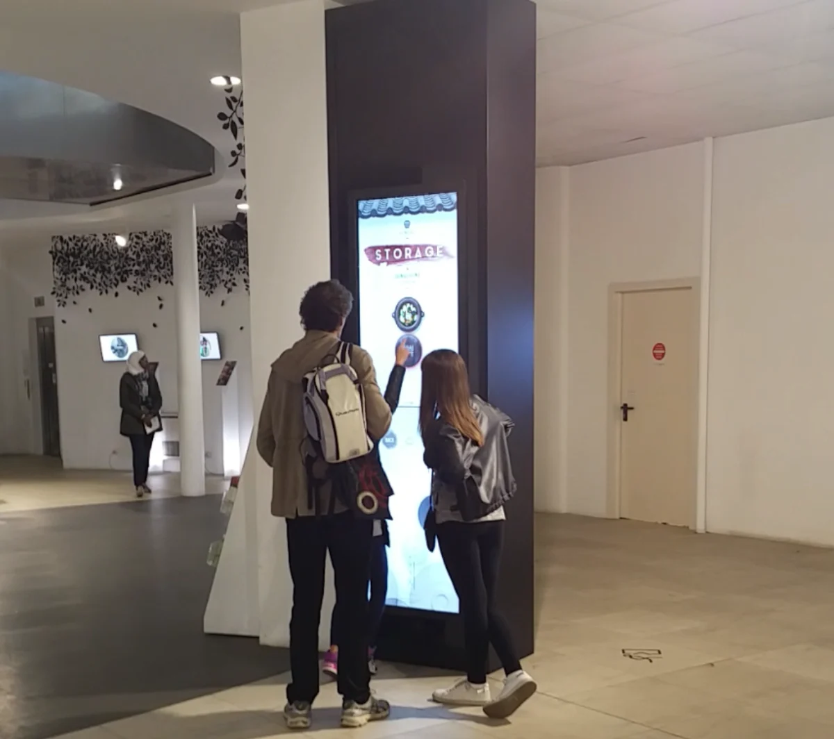 밀라노 엑스포 한국관에서 관람객 두 명이 세로형 터치 키오스크를 조작하는 모습